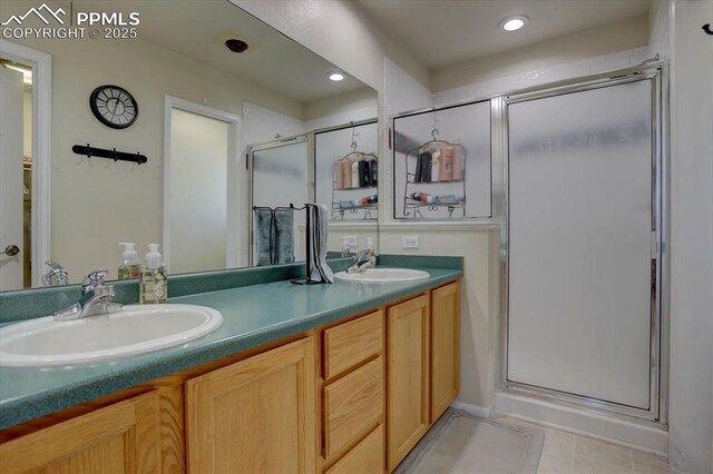 bathroom with double vanity, a stall shower, and a sink