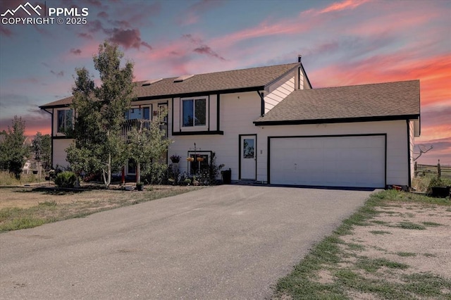 view of front of property featuring an attached garage and aphalt driveway