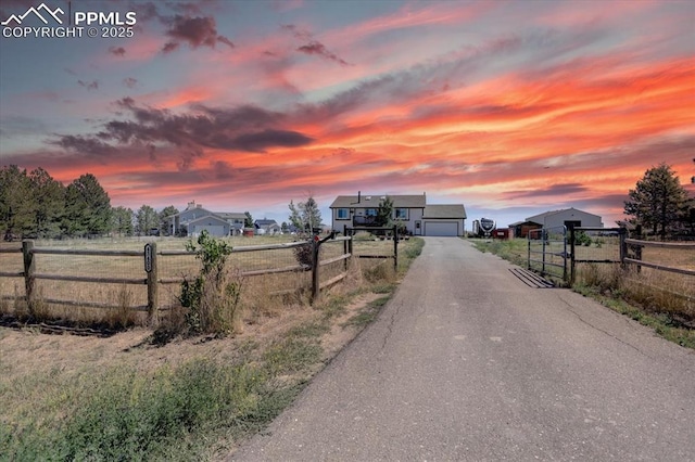 view of road featuring aphalt driveway, a rural view, and a gated entry