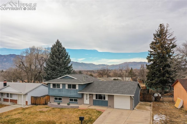 view of front facade with a mountain view, a garage, and a front yard