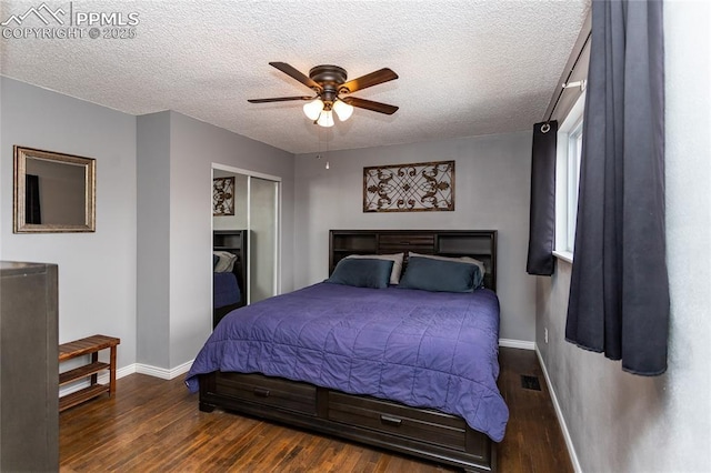 bedroom featuring a textured ceiling, a closet, ceiling fan, and dark wood-type flooring