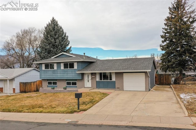 tri-level home featuring a garage and a front lawn