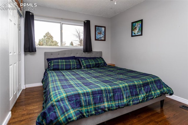 bedroom featuring a textured ceiling and dark wood-type flooring