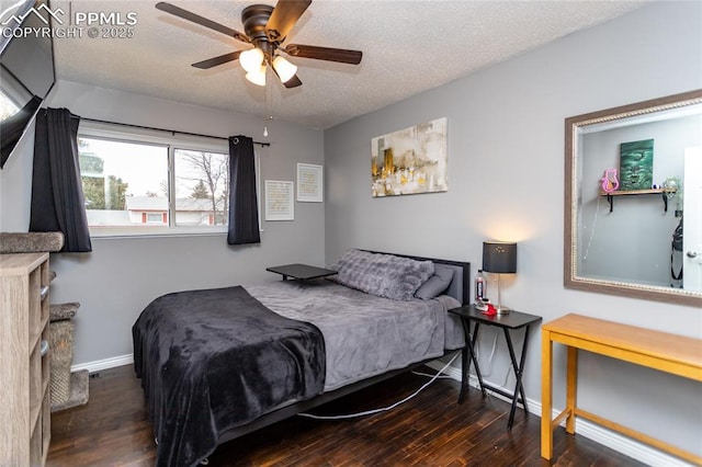 bedroom with a textured ceiling, ceiling fan, and dark hardwood / wood-style floors