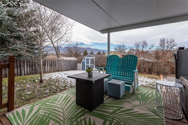 view of patio / terrace with a mountain view and a storage shed