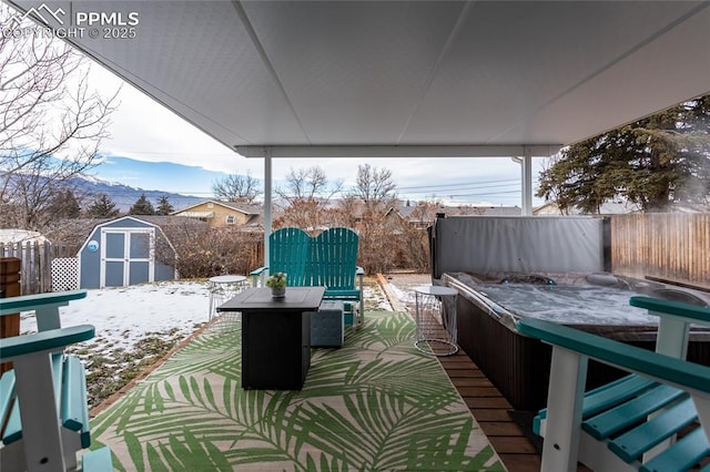 snow covered deck with a storage shed