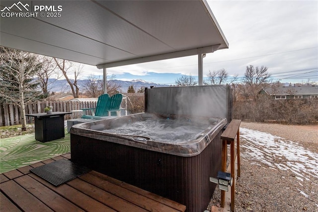 deck with a mountain view and a hot tub