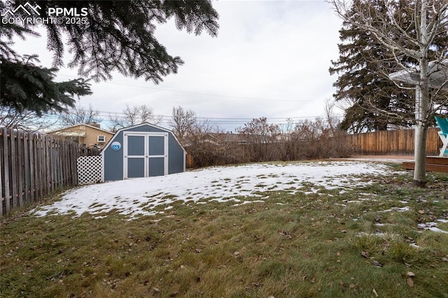 yard layered in snow featuring a storage unit