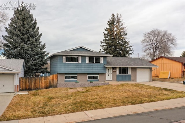 split level home with a garage and a front lawn