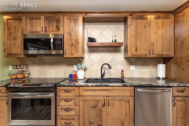 kitchen with decorative backsplash, sink, appliances with stainless steel finishes, and dark stone counters