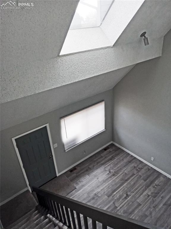 bonus room featuring dark hardwood / wood-style floors and vaulted ceiling