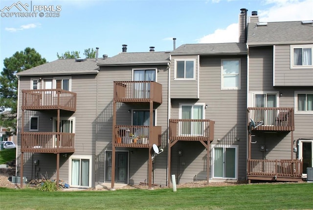 rear view of property with a lawn and central AC unit