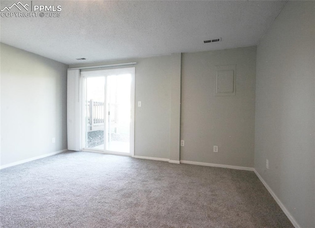 carpeted spare room with a textured ceiling