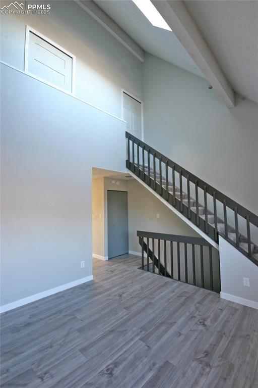 interior space featuring beamed ceiling, hardwood / wood-style floors, and high vaulted ceiling