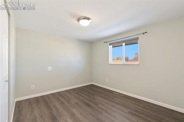 unfurnished room with dark hardwood / wood-style flooring