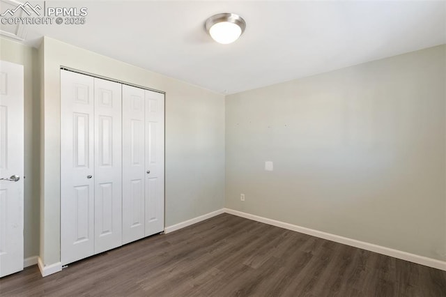 unfurnished bedroom featuring dark wood-type flooring and a closet