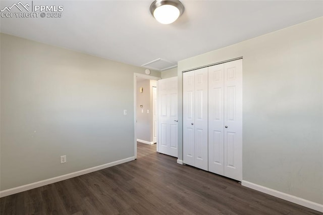 unfurnished bedroom featuring a closet and dark hardwood / wood-style floors