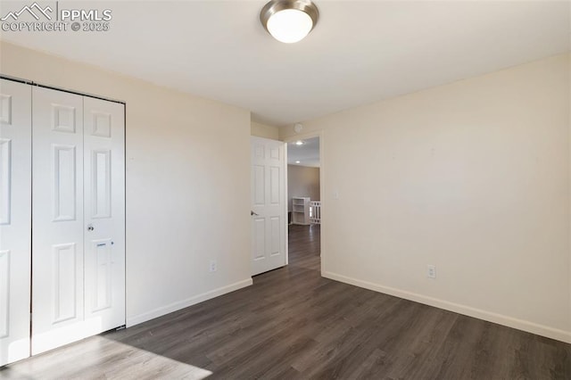 unfurnished bedroom with dark hardwood / wood-style floors and a closet