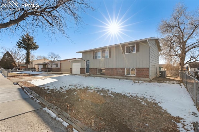 view of front of home with a garage and central air condition unit