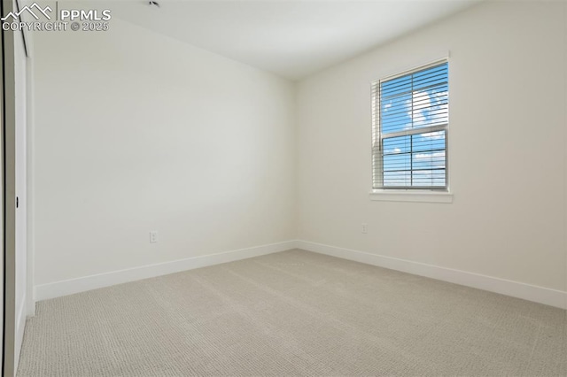 spare room featuring light carpet