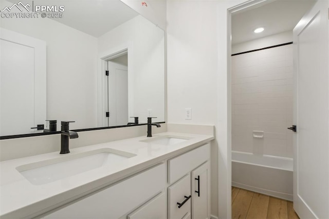 bathroom featuring hardwood / wood-style floors, vanity, and shower / bath combination