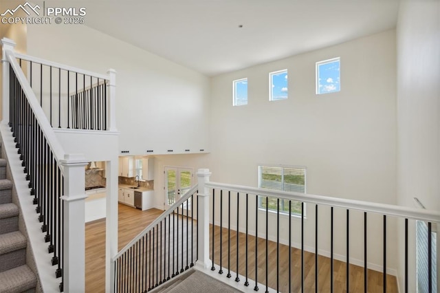 stairs featuring hardwood / wood-style floors and sink