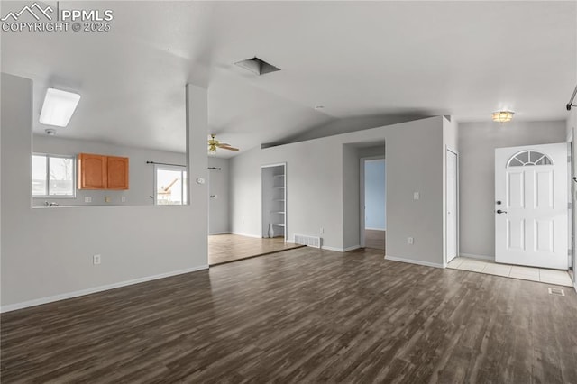 unfurnished living room with baseboards, visible vents, ceiling fan, wood finished floors, and vaulted ceiling