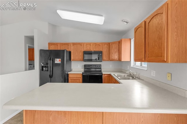 kitchen featuring light countertops, a sink, a peninsula, and black appliances