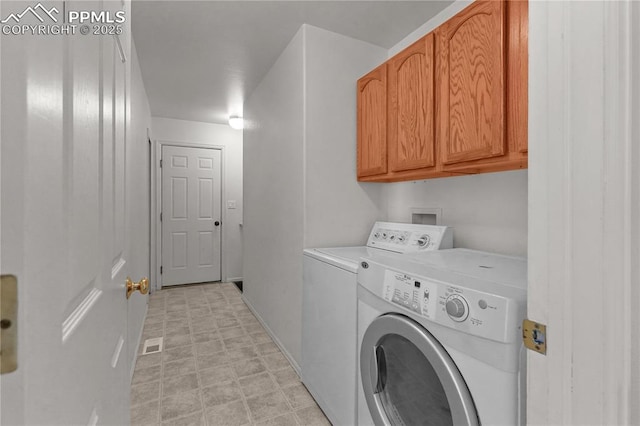 laundry room with light floors, washing machine and clothes dryer, and cabinet space