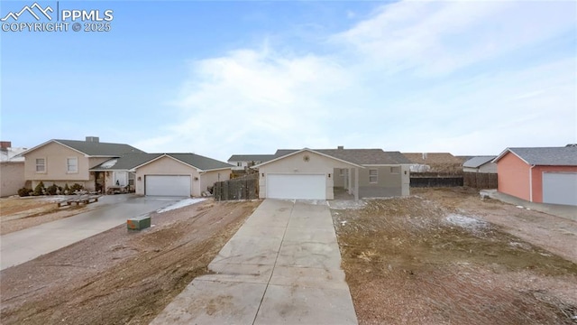 single story home featuring a residential view, concrete driveway, fence, and an attached garage