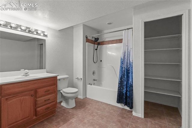 bathroom with a spacious closet, toilet, shower / bath combo with shower curtain, vanity, and a textured ceiling