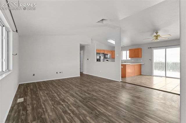 unfurnished living room with lofted ceiling, baseboards, visible vents, and wood finished floors