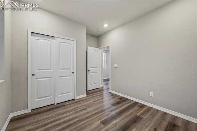 unfurnished bedroom featuring dark hardwood / wood-style flooring and a closet