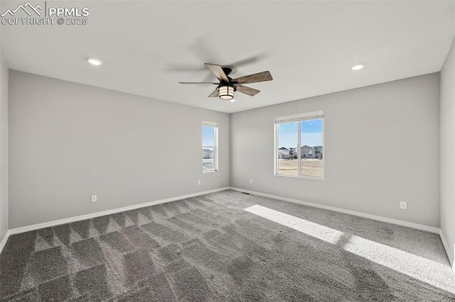 empty room with dark colored carpet and ceiling fan