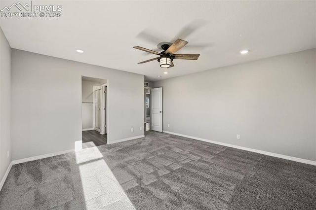 unfurnished room with ceiling fan and dark colored carpet