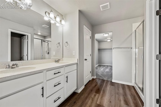 bathroom with vanity, hardwood / wood-style flooring, and a shower with shower door