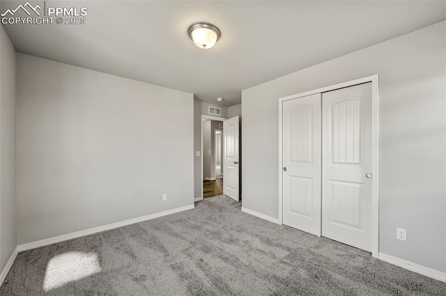 unfurnished bedroom featuring a closet and light colored carpet