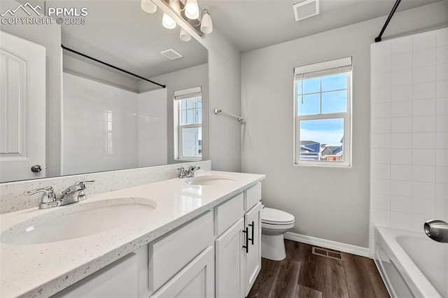 full bathroom featuring vanity, hardwood / wood-style flooring, toilet, and a wealth of natural light