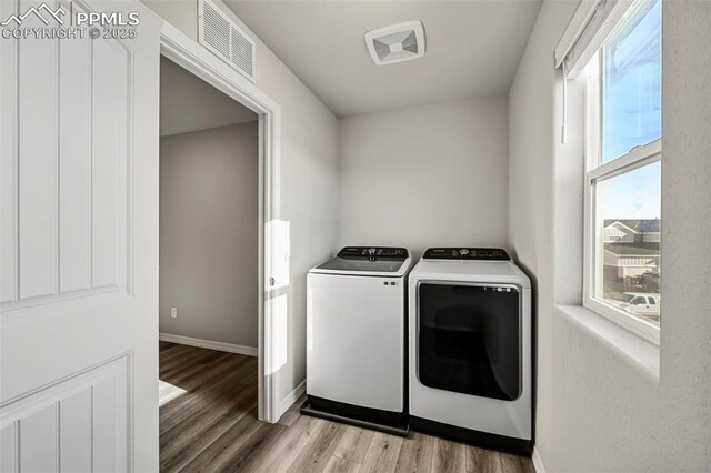 washroom with separate washer and dryer, plenty of natural light, and light hardwood / wood-style floors