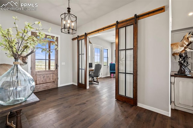 foyer entrance featuring a barn door, dark wood-type flooring, a healthy amount of sunlight, and french doors