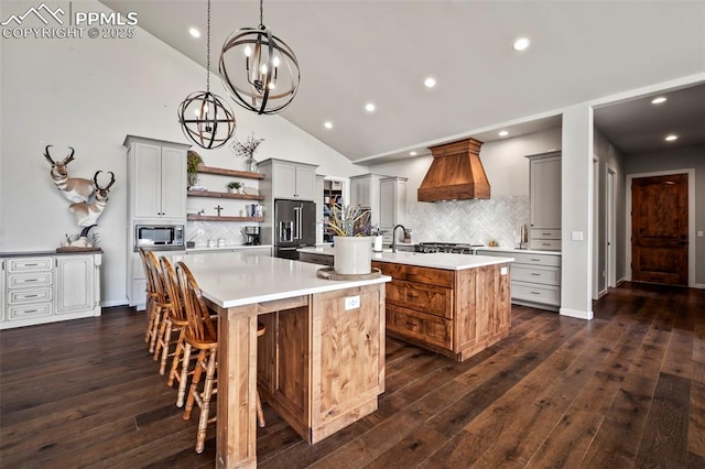 kitchen featuring backsplash, stainless steel appliances, gray cabinets, and a kitchen island with sink