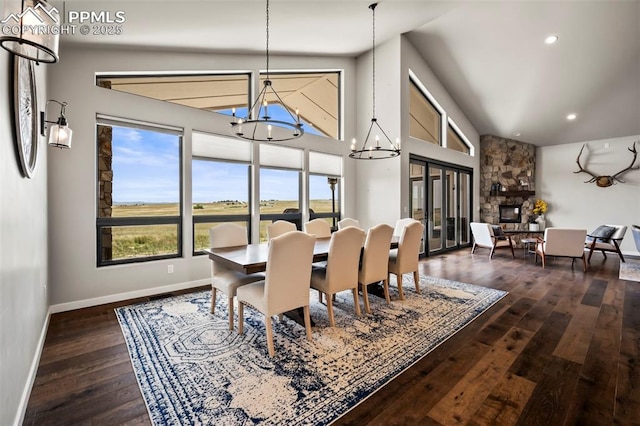 dining room with a fireplace, an inviting chandelier, and dark wood-type flooring