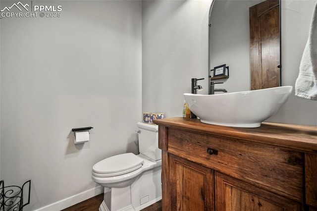 bathroom with hardwood / wood-style floors, vanity, and toilet