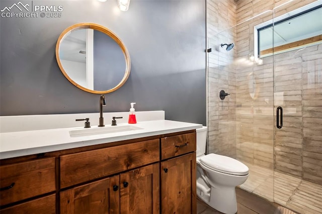 bathroom with tile patterned floors, vanity, a shower with shower door, and toilet