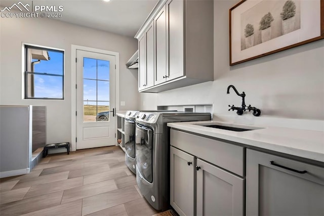 laundry room with cabinets, sink, and washing machine and clothes dryer