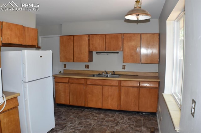 kitchen with sink, decorative light fixtures, and white refrigerator