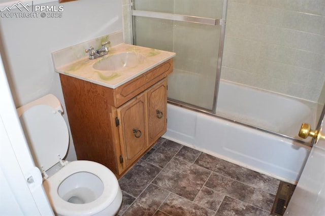 full bathroom with vanity, enclosed tub / shower combo, and toilet