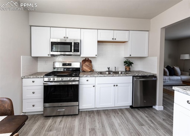 kitchen with white cabinets, stainless steel appliances, and sink