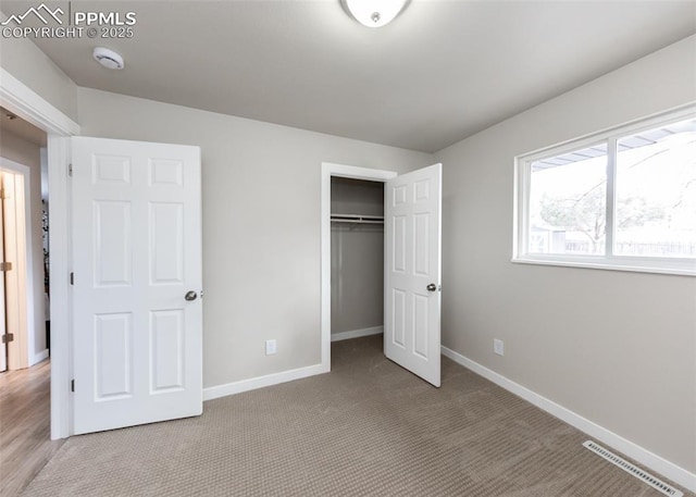 unfurnished bedroom featuring light colored carpet and a closet