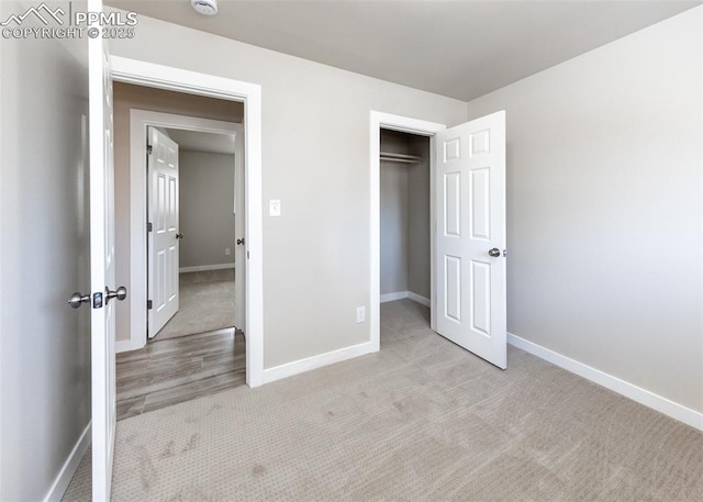 unfurnished bedroom featuring a closet and light colored carpet